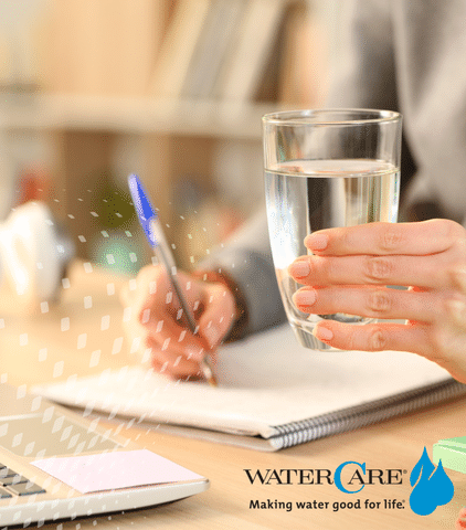 Girl holding glass of water while taking notes